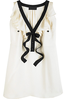 Ivory sleeveless silk blouse with contrast black trim and a ruffle trim V-neck.