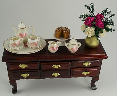 This 1:12 Scale Dolls House Miniature Mahogany Sideboard is set with a pretty pink and cream