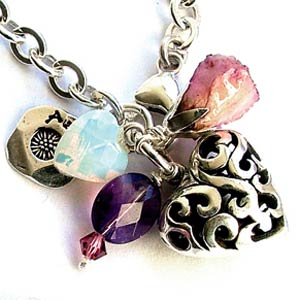 Silver link chain bracelet with a small, detailed filligree heart a pale pink abalone shell leaf,
