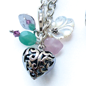 Silver link chain bracelet with a small, detailed filligree heart a cream abalone shell leaf,