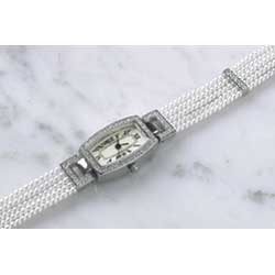 An exceptional dress watch featuring five strings of faux pearls and a curved case framed with