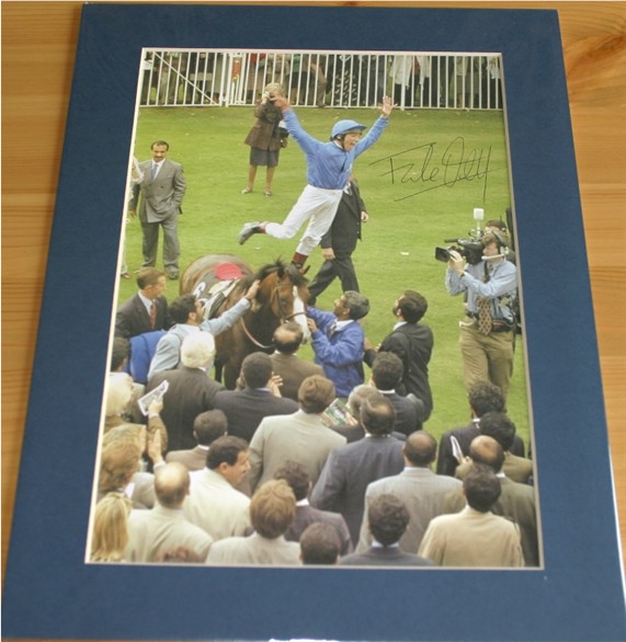 Terrific colour photo of jockey Frankie Dettori doing a trademark flying dismount - signed in black
