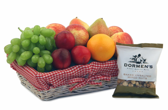 Beautifully presented fresh fruit in a red gingham lined wicker basket with Dormen`s baked mixed nut