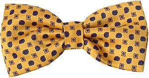 Gold bow tie with darker gold squares and dark blue circles filled with red