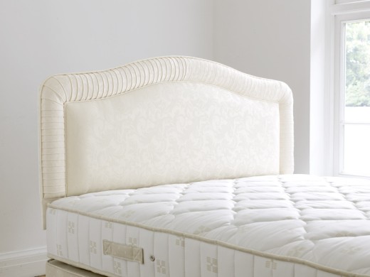 Stylish upholstered headboard with pleated border and piped edging. Available in a variety of finish