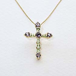 In an exquisitely delicate design, this hallmarked 9ct gold pendant cross is set with peridot and