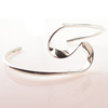 A sinuous silver bangle with great beauty in its curves.