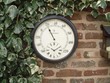A very attractive thermometer with a built in clock in a metal surround that is slate grey in colour