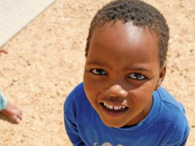 Unbranded Volunteer with children in a township near Cape