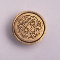 A solid celtic rose brass seal has a wooden handle to allow you to impress it into hot sealing-wax. 